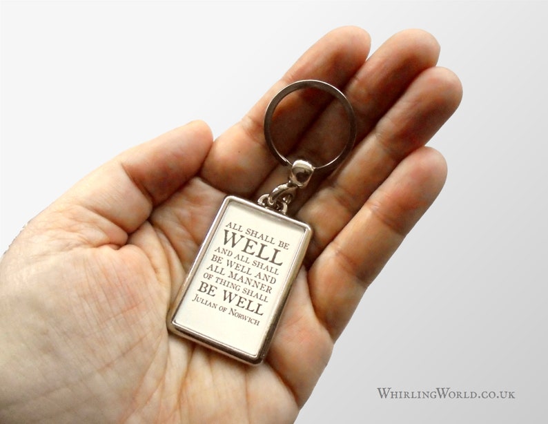 May include: A silver keychain with a rectangular charm that reads "ALL SHALL BE WELL AND ALL SHALL BE WELL AND ALL MANNER OF THING SHALL BE WELL JULIAN OF NORWICH".