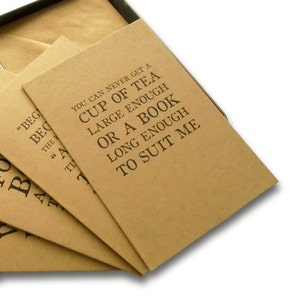 May include: Four brown paper cards with black text. The top card reads "You can never get a cup of tea large enough or a book long enough to suit me."