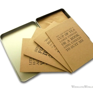 May include: A set of four brown kraft paper cards with black text quotes about tea and books. The cards are in a silver tin box with a brown paper liner.