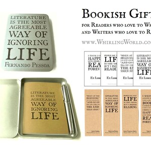 May include: A silver metal box with a quote about literature printed on the front. The quote reads "Literature is the most agreeable way of ignoring life." The quote is attributed to Fernando Pessoa. The box is open and contains a small notebook with the same quote printed on the cover. The box also contains a silver pen. There are four bookmarks with quotes about literature and reading. The bookmarks are printed on brown paper.