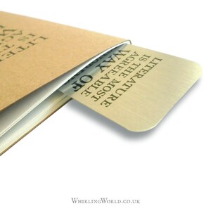 May include: A silver bookmark with the text "LITERATURE IS THE MOST AGREEABLE WAY OF...