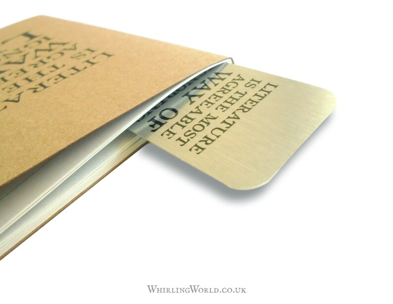 May include: A silver bookmark with the text "LITERATURE IS THE MOST AGREEABLE WAY OF...