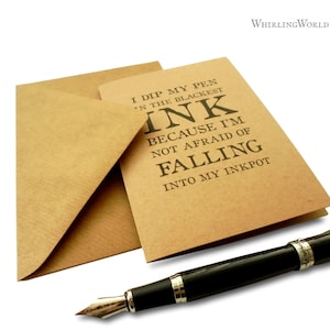 May include: A brown card with the text "I dip my pen in the blackest ink because I'm not afraid of falling into my inkpot".