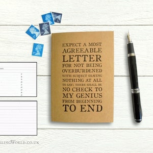 May include: A brown notebook with the text "EXPECT A MOST AGREEABLE LETTER FOR NOT BEING OVERBURDENED WITH SUBJECT (HAVING NOTHING AT ALL TO SAY) THERE SHALL BE NO CHECK TO MY GENIUS FROM BEGINNING TO END" printed on the cover.