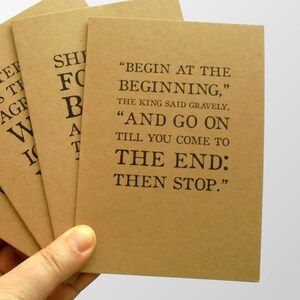 May include: A brown card with the text "Begin at the beginning," the king said gravely, "And go on till you come to the end: Then stop."