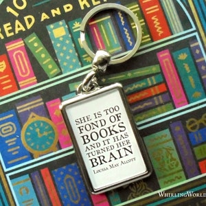 May include: A silver keychain with a white rectangular charm that reads "She is too fond of books and it has turned her brain. Louisa May Alcott."