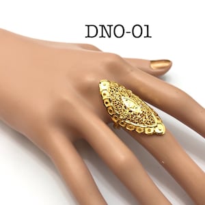 May include: A gold ring with a filigree design. The ring is oval shaped and has a textured surface. DNO-01