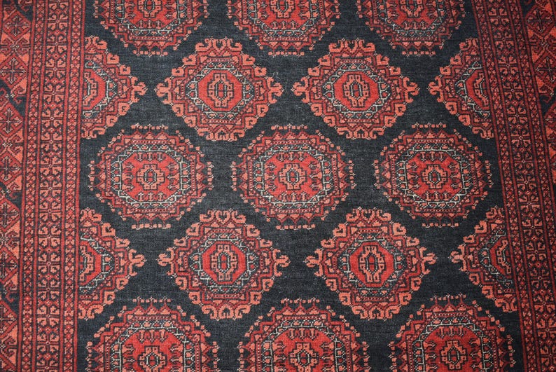 May include: A close-up of a traditional Persian rug with a dark blue background and intricate red and white patterns. The rug features a repeating design of floral motifs and geometric shapes.