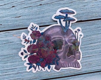 May include: A sticker featuring a purple skull with a bouquet of dark pink roses and blue mushrooms growing from the top of the skull.
