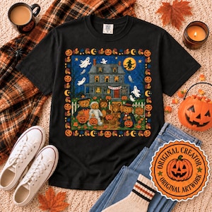 Puede incluir: Una camiseta negra con un gráfico de una casa encantada con fantasmas y una bruja en una escoba. Debajo, cinco osos de peluche con disfraces de Halloween sostienen cubos de calabaza. El diseño está enmarcado por un borde de calabazas y hojas.