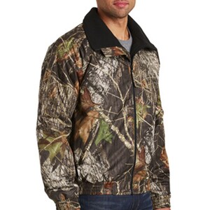 May include: A camouflage print jacket with a black fleece lining. The jacket has a zipper closure and a stand-up collar.