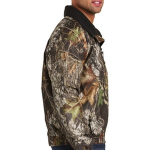May include: A camouflage print jacket with a black collar and zipper closure. The jacket has a relaxed fit and is made of a lightweight, water-resistant fabric.