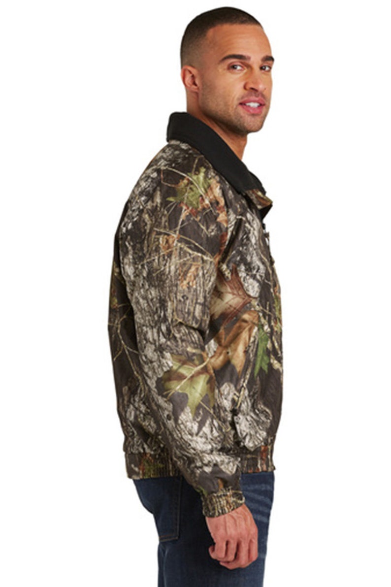 May include: A camouflage print jacket with a black collar and zipper closure. The jacket has a relaxed fit and is made of a lightweight, water-resistant fabric.