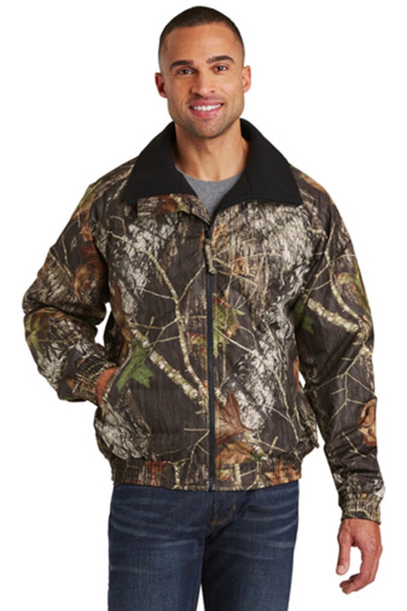 May include: A camouflage print jacket with a black fleece lining and a zipper closure.