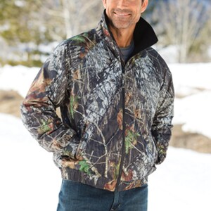 May include: A camouflage print jacket with a black zipper and a black fleece lining. The jacket has a stand-up collar and two pockets.