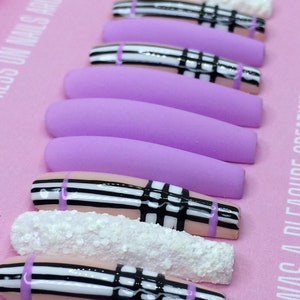 May include: Set of long, lavender and pink press-on nails with a black and white plaid design and white glitter accents.