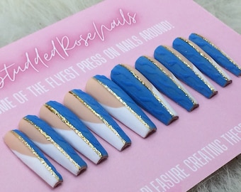 Puede incluir: Conjunto de diez uñas postizas largas, azules y blancas con un acento dorado. Las uñas tienen un diseño texturizado y tejido.