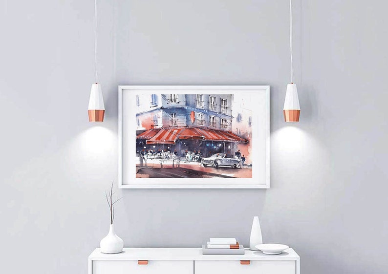 Puede incluir: Una pintura de acuarela de una escena callejera parisina con un caf&eacute;, un toldo rojo y un coche aparcado delante. El caf&eacute; tiene mesas y sillas dispuestas en el exterior, y la gente est&aacute; sentada y de pie alrededor. El edificio est&aacute; pintado en un color gris claro con molduras blancas.