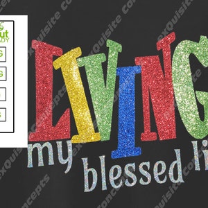 May include: A black t-shirt with the words "Living my blessed life" in colorful glitter letters. The letters are red, yellow, green, and blue.