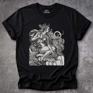Op de afbeelding: Een zwart t-shirt met korte mouwen en een witte grafische print van een mythologische figuur zittend tussen wervelende wolken en een slang. De binnenkant van de halslijn toont de witte tekst Lucis Aeterna in een gotisch lettertype.