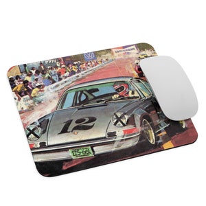 May include: A vintage illustration of a silver race car with the number 12 on the side, driving on a red racetrack. The car is surrounded by a crowd of people and a white mouse pad.