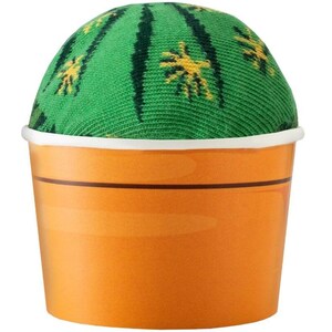Op de afbeelding: Een groene en gele cactusvormige sok in een bruin en wit papieren bekertje.