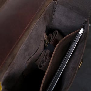 May include: A brown leather backpack with a zippered pocket and a large compartment for a laptop or tablet.