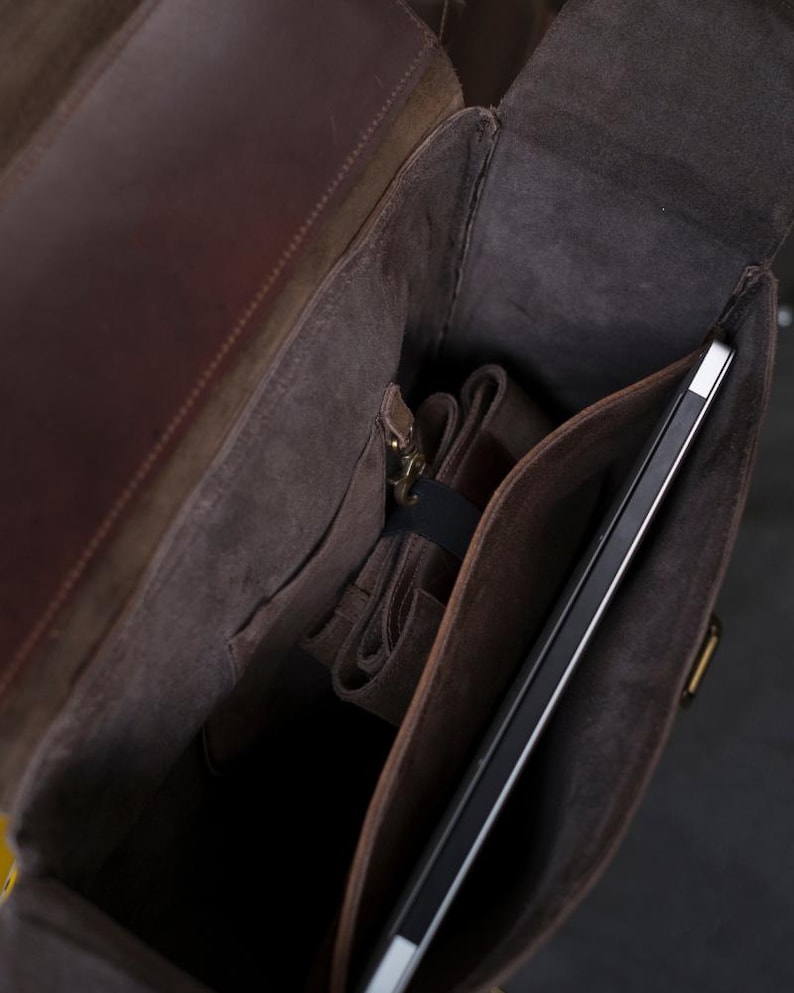 May include: A brown leather backpack with a zippered pocket and a large compartment for a laptop or tablet.