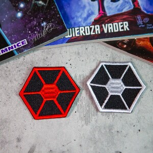 May include: Two embroidered patches featuring the Death Star symbol. One patch is red and black, the other is white and black.