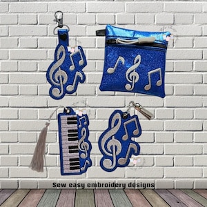 May include: A collection of blue musical-themed accessories, including a keychain, a small zippered pouch, a bookmark with a tassel, and a keychain. Each item features musical notes and treble clef designs.