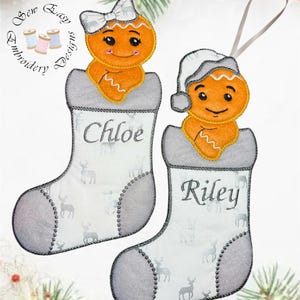 May include: Two Christmas stocking ornaments with gingerbread men. One gingerbread man wears a bow, the other a hat. The stockings are white with a deer pattern and the names "Chloe" and "Riley".