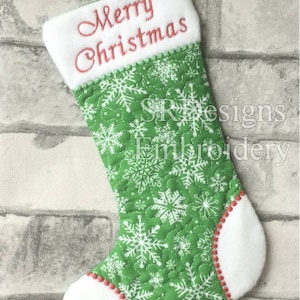 Puede incluir: Calcetín de Navidad verde con copos de nieve blancos y el texto "Merry Christmas" bordado en rojo en el puño.