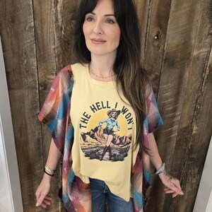 La maglietta "Hell I Won't" è stata trasformata in un poncho colorato con una sciarpa altrettanto colorata.