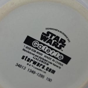 Może przedstawiać: Biały ceramiczny przedmiot z logo Star Wars i słowem "Galerie" w kolorze czarnym. Widoczny jest r&oacute;wnież tekst "Dishwasher & Microwave Safe". Wyprodukowano w Chinach.