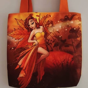May include: Orange tote bag featuring a fairy with red hair and a yellow dress, surrounded by autumn leaves and a warm, reddish-orange background. The bag has orange straps.