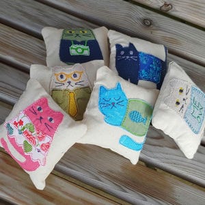 handmade square cotton pouch with embroidered cat design on front. filled with polyfil and fresh catnip. six designs