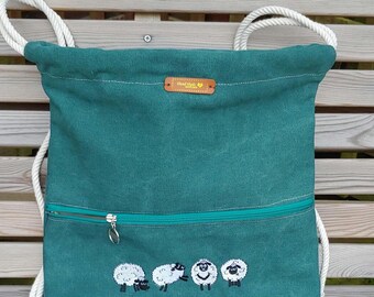 Drawstring backpack. Handmade and embroidered sheep detail. Canvas green with front zipped pocket. Roomy rustic bag. Unisex gift.