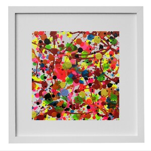 Könnte beinhalten: Abstraktes Kunstwerk in einem weißen Rahmen mit einem farbenfrohen Spritzmuster. Das Kunstwerk zeigt eine dynamische Anordnung von Farbspritzern in verschiedenen Farbtönen, darunter Rot, Gelb, Blau und Grün, wodurch eine lebendige und energiegeladene Komposition entsteht. Das Gemälde ist mit einem sauberen weißen Rand gerahmt.