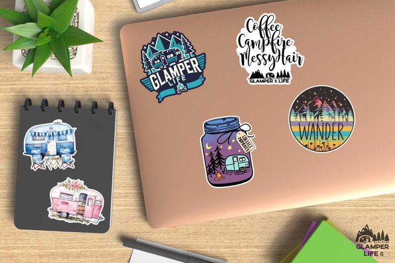 Op de afbeelding: Een verzameling kleurrijke stickers met kampeer- en reisthema's. Ontwerpen omvatten een blauwe en turquoise camper met de tekst "GLAMPER LIFE", een pot met een camper en de tekst "COLLECT MOMENTS", en een ronde sticker met het woord "WANDER".