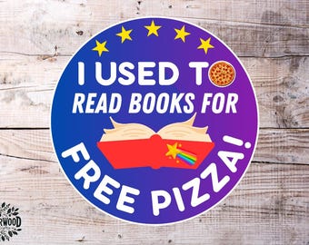 May include: A round sticker with a blue and purple gradient background. The text "I USED TO READ BOOKS FOR FREE PIZZA!" is in white. The design includes a pizza slice, an open book, stars, and a rainbow.