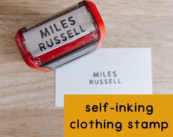 May include: Red self-inking clothing stamp with the name "MILES RUSSELL" printed on it.