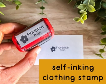 May include: Red self-inking clothing stamp with a black flower and the text "Florence Tran".