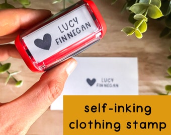 May include: Red self-inking clothing stamp with a white label that says "LUCY FINNEGAN" and a black heart.