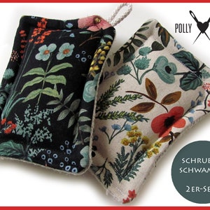 Könnte beinhalten: Zwei Geschirrtücher mit floralem Muster, eines in Schwarz-Weiß, das andere in Creme und mehrfarbigen Blumen. Die Geschirrtücher sind mit "Schrubb-Schwamm 2er-Set" und "Polly Poison" beschriftet.