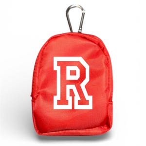 May include: A small, red backpack-shaped pouch with a white letter "R" printed on the front. The pouch has a silver carabiner clip attached to the top for easy attachment to a bag or keychain.