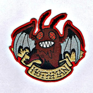 Op de afbeelding: Rode geborduurde patch met een cartoonmonster met vleugels en de tekst "Gettin' Weird" in een banner.