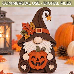 May include: A layered wooden gnome decoration featuring a dark brown hat with an orange band, a star accent, and a cluster of autumn leaves. The gnome has a light-coloured beard, a round nose, and holds an orange jack-o'-lantern pumpkin.