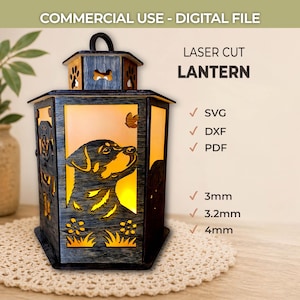 Puede incluir: Linterna cortada con láser con diseño de perro. La linterna negra tiene un brillo amarillo cálido desde el interior. El diseño incluye un perro, una mariposa y elementos florales. El texto "COMMERCIAL USE - DIGITAL FILE" y "LASER CUT LANTERN" son visibles.