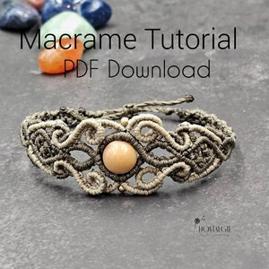 Può includere: Un braccialetto in macramè con un ciondolo di pietra rosa chiaro e dettagli dorati. Il braccialetto è realizzato con cordoncino grigio e beige. L'immagine include il testo "Macrame Tutorial PDF Download".