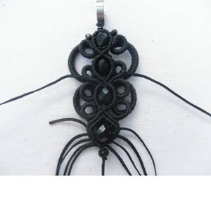 May include: Black macrame pendant with black beads and a silver loop at the top.